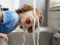 enfant boit l'eau du robinet